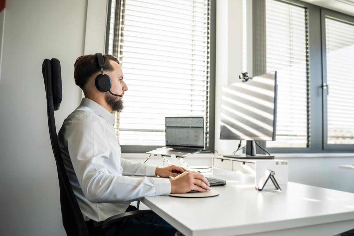 Mann im Büro mit Headset bei der telefonischen Qualifizierung von Leads.