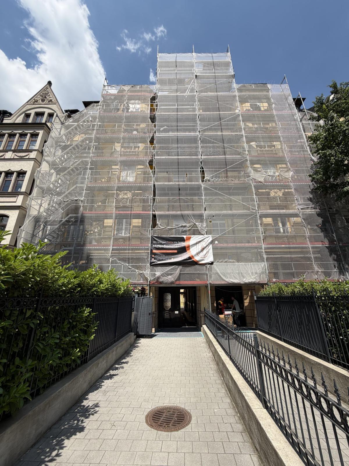 Fassade eines Gebäudes mit Gerüst für Fassadenanstrich zur Werterhaltung.