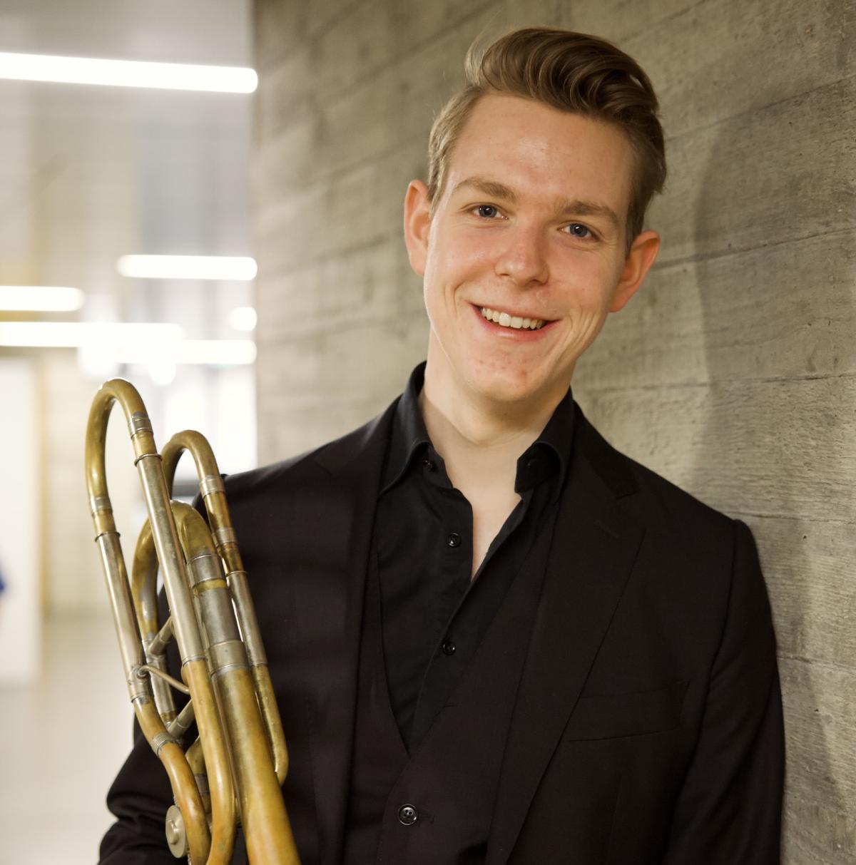 Ein Musiker mit Blechblasinstrument zeigt, wie wichtig die Technik beim Erlernen eines Blechblasinstruments ist.