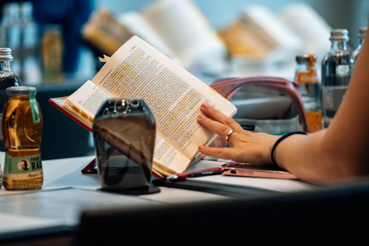Eine Hand blättert in einem Buch während der Steuerberaterprüfung Vorbereitung.