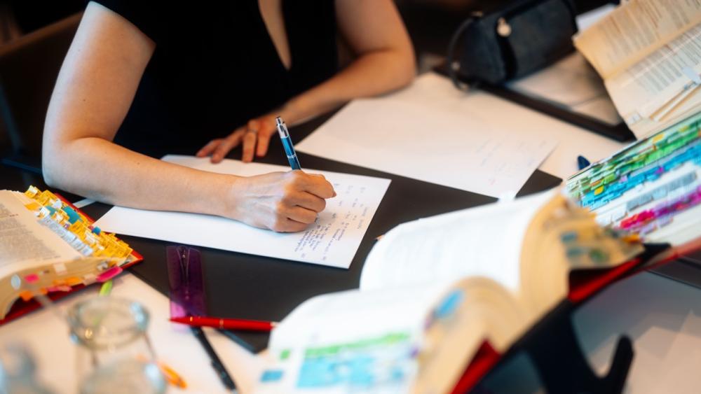 Studierende bei der Vorbereitung auf die Steuerberaterprüfung mit Büchern und Unterlagen.