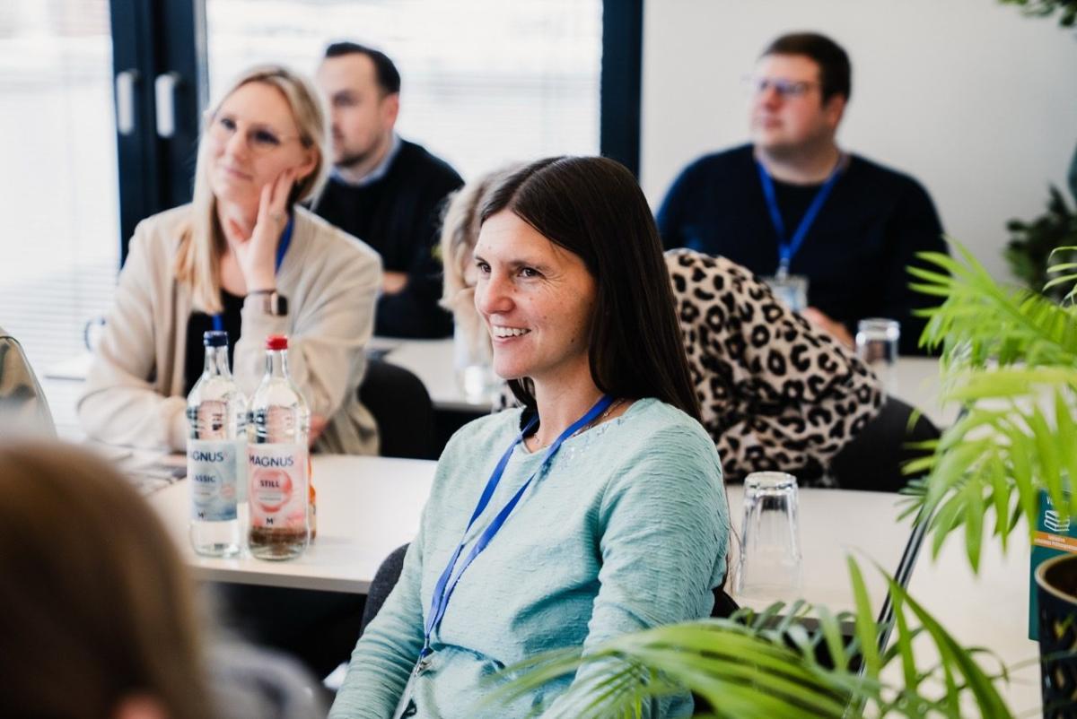 Eine Teilnehmerin lächelt während eines Seminars zur Steuerberaterprüfung.