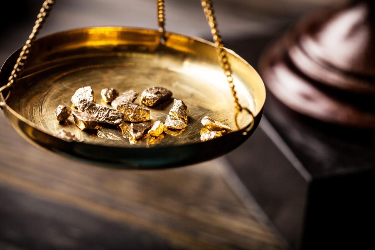 Eine Goldwaage zeigt Goldstücke, wichtig beim seriösen Edelmetallhändler.