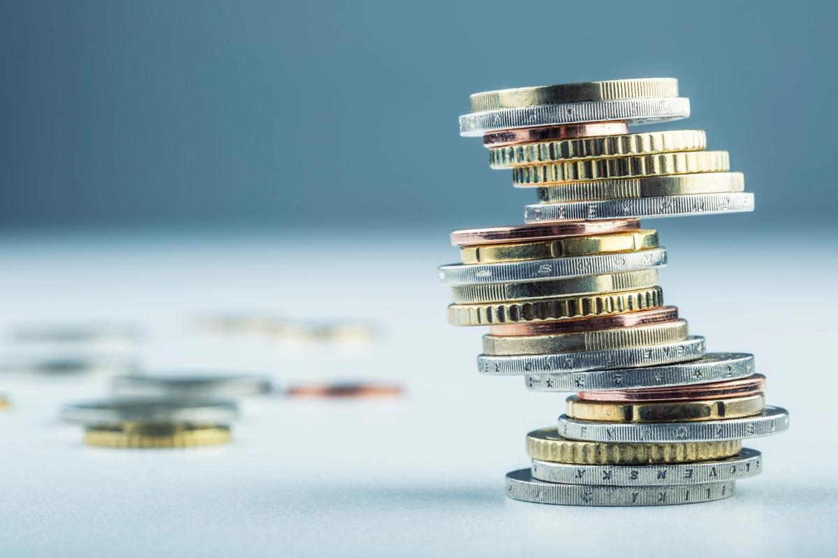 Ein Stapel von Münzen zeigt, warum Gold kaufen eine überlegenswerte Investition ist.