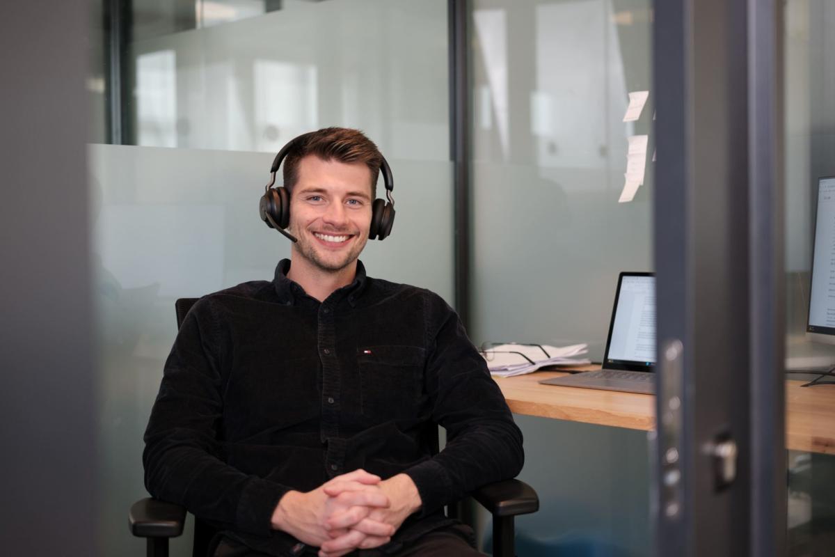 Mitarbeiter im Büro mit Headset zeigt IT-Gehälter Hamburg.