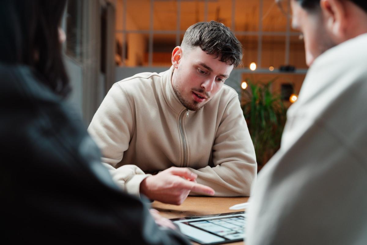 Mann erklärt bei einer Sitzung mit Tablet die Answer Engine Optimization.
