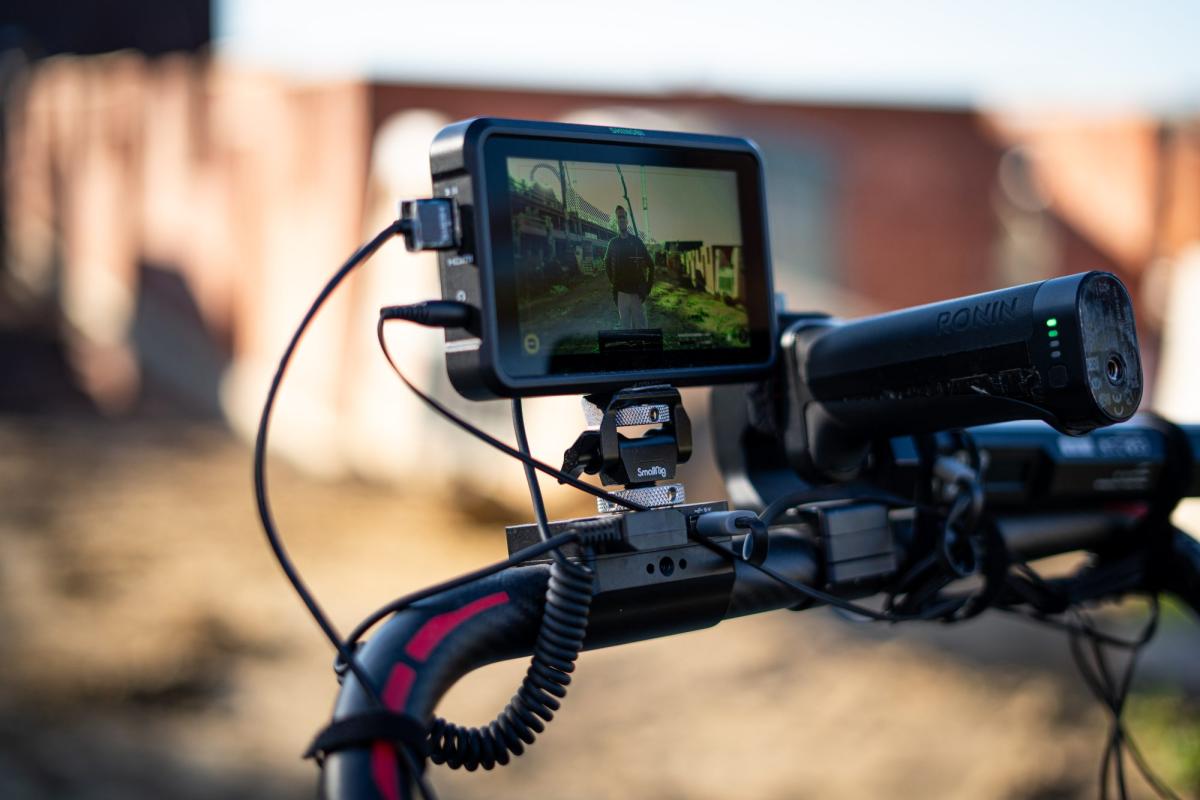 Videokamera mit angeschlossenem Monitor beim Filmen im Freien für Social Media im Betrieb.